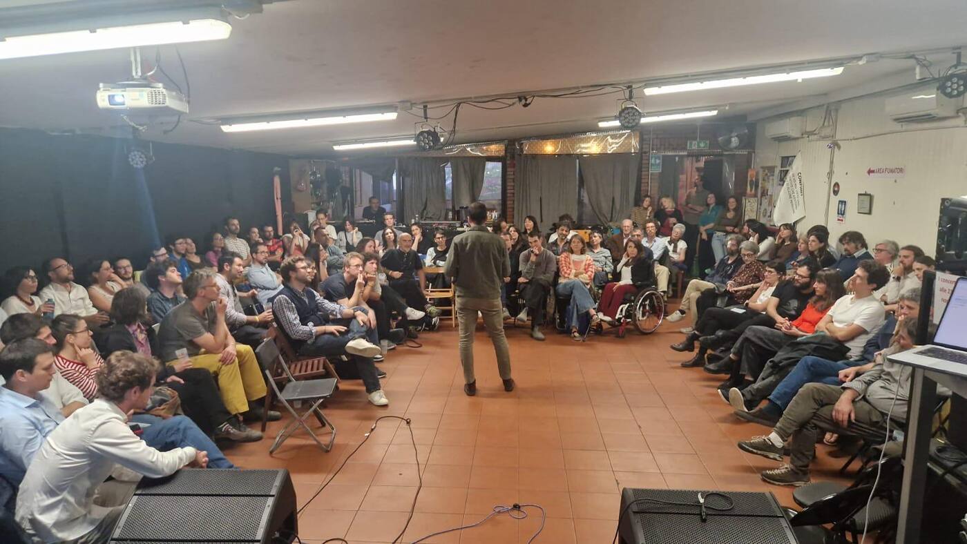 Un'agorà in una sala piena di persone sedute in cerchio