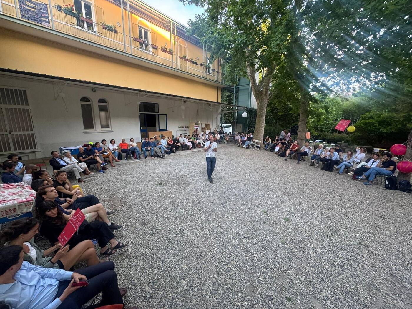 Un'agorà all'aperto, in un cortile: persone sedute in cerchio